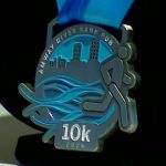 Race officials show off the design for the medals for the upcoming 2024 Amway River Bank Run. (WOOD TV8)