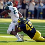 In this 2010 file photo, Michigan linebacker Obi Ezeh tries to tackle Michigan State running back Larry Caper. (AP file)