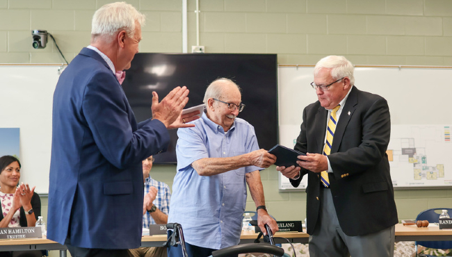 Bob Bonhomme receives an honorary diploma from PPS Board of Education President Randy Van Antwerp, right, and Superintendent Mark Bielang on Monday, June 10, 2024. (Courtesy Portage Public Schools)